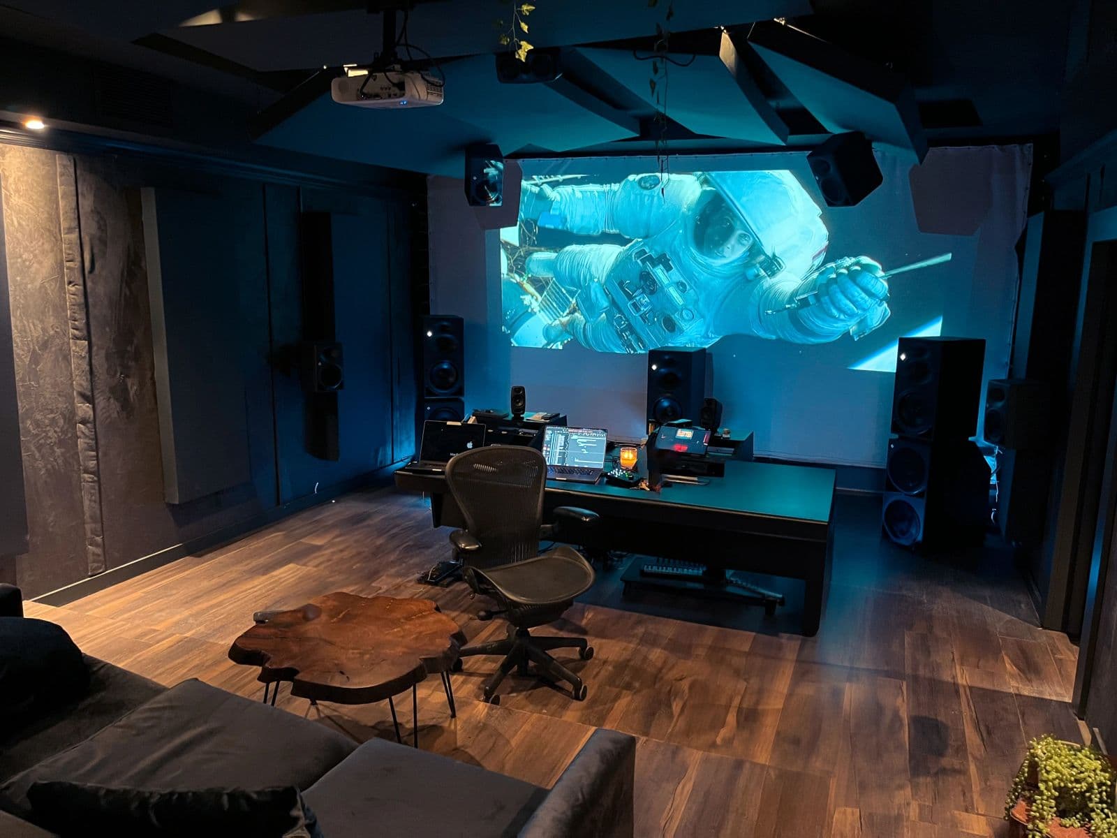 The Dolby Atmos theatre with a film projected across the 17-foot cinema screen, the mix desk and Neumann monitors centered in the room