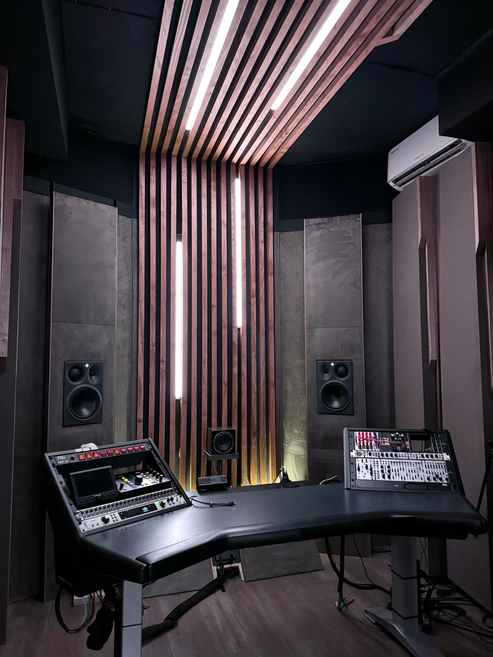The connected flex B-room, a walnut-slat production suite with Neumann monitoring and a mix console